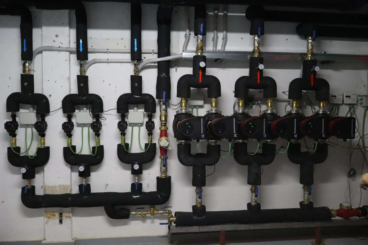 Sistema hidráulico con varias bombas circuladoras, válvulas y tuberías aisladas distribuidas sobre una pared técnica, destinado a la circulación y regulación del agua en una instalación de climatización o calefacción.