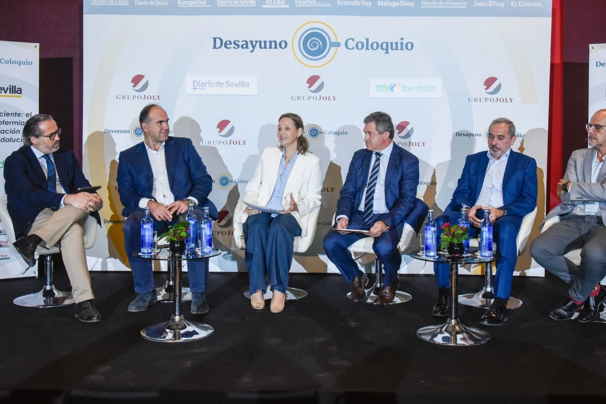 Mesa redonda o coloquio empresarial con seis participantes sentados en un escenario durante un evento organizado por Grupo Joly. Al fondo se observa un panel con el título “Desayuno Coloquio” y logotipos de entidades colaboradoras.