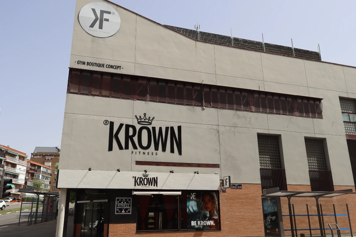 Fachada exterior del gimnasio Krown Fitness, un edificio urbano de varias plantas con la imagen corporativa del centro, acceso principal a pie de calle y señalización visible en la fachada.