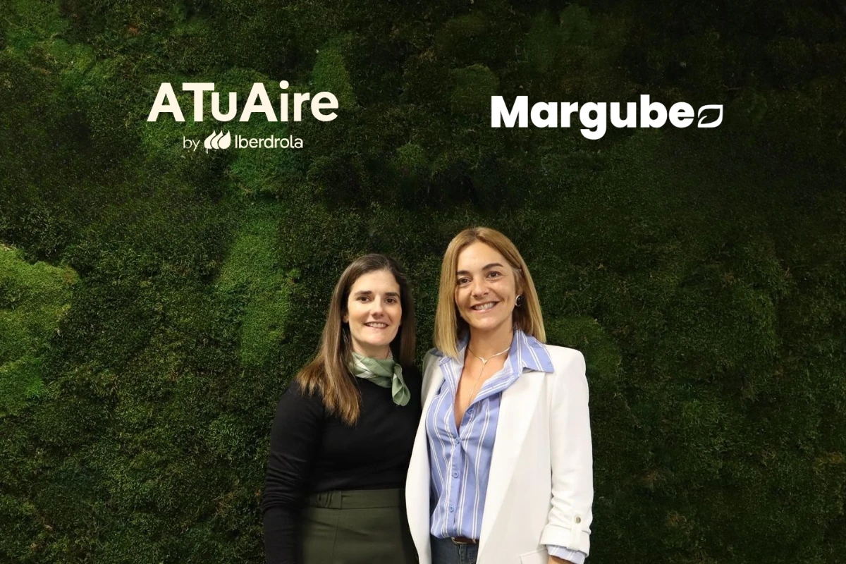Dos representantes de empresas posan frente a un muro vegetal corporativo con los logotipos de ATuAire by Iberdrola y Margube visibles en la parte superior, en un entorno destinado a reuniones o eventos profesionales.