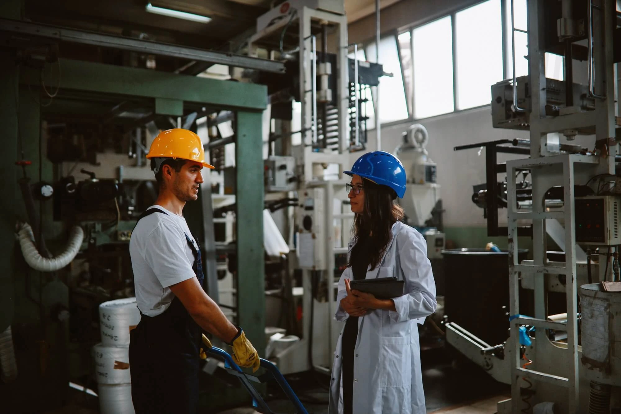 Profesionales supervisando procesos industriales y oportunidades de implantación de aerotermia para industrias en una planta de producción.